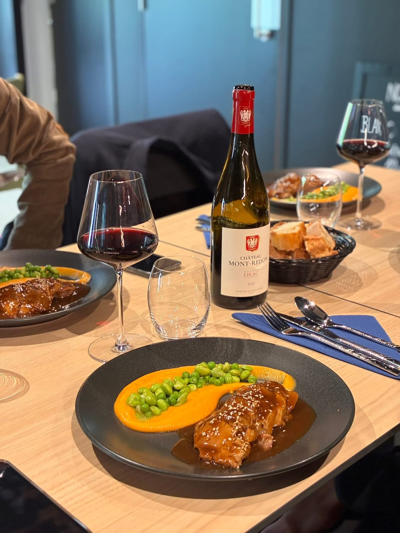 Un plat dressé à Esprit Restaurant, accompagné d'un verre de vin